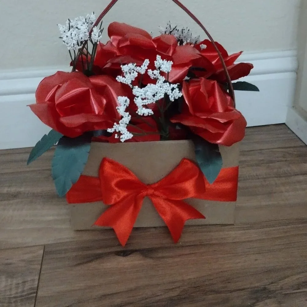 Handmade floral arrangement with plastic ribbon roses.